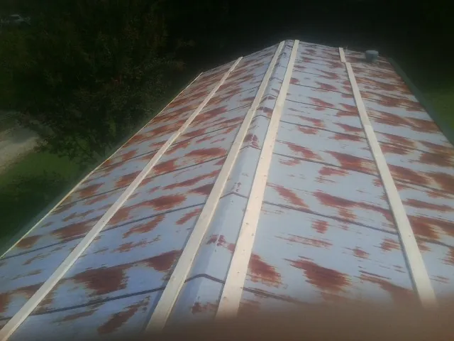 Rusted metal roof panels with new wood purlins before replacement — Storm Damage Roof Repair in Millers Falls by Roofing Brothers